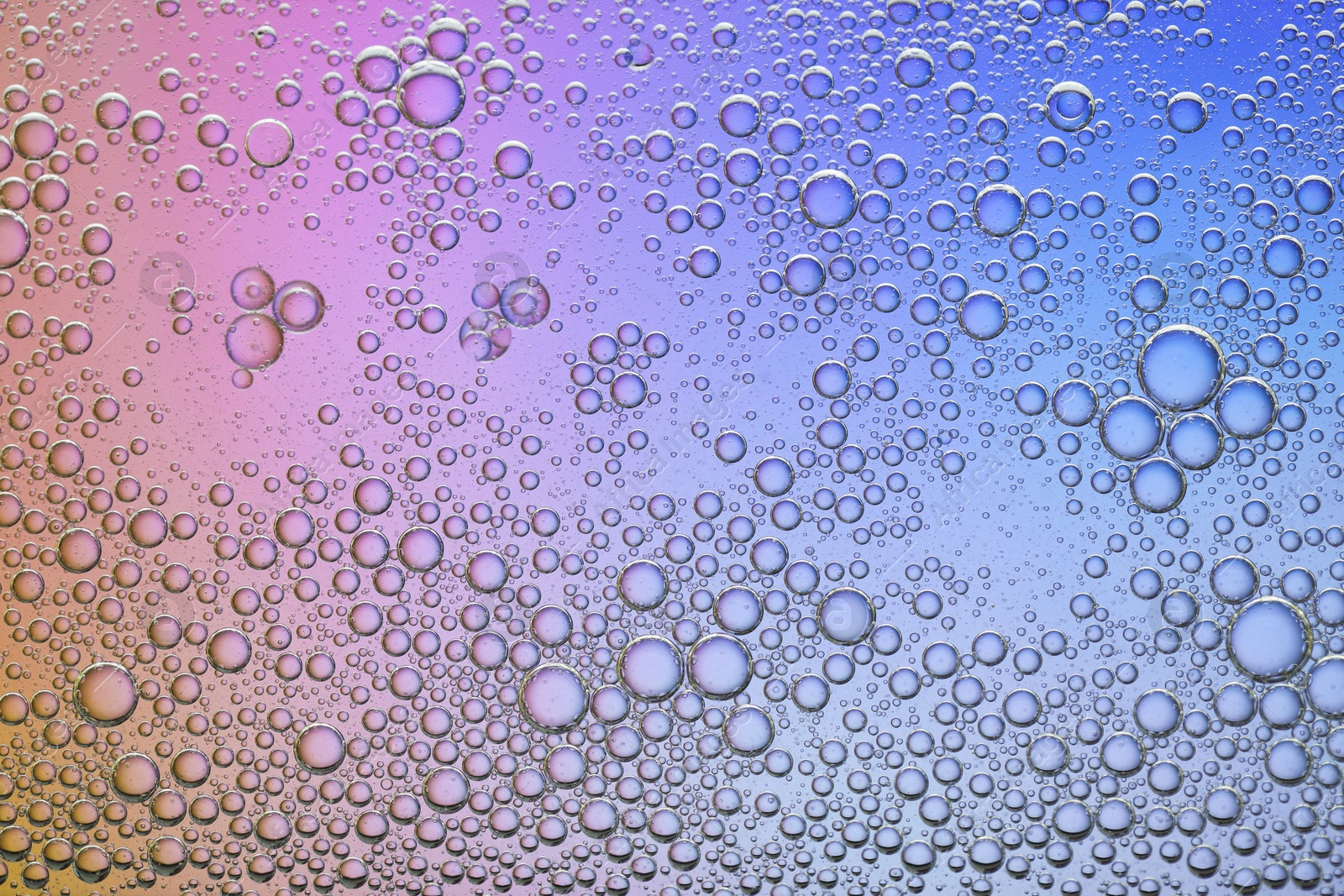 Photo of Essential oil bubbles on color background, macro view. Cosmetic product