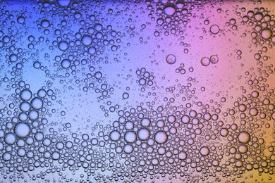 Essential oil bubbles on color background, macro view. Cosmetic product