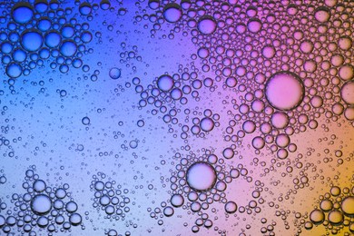 Photo of Essential oil bubbles on color background, macro view. Cosmetic product