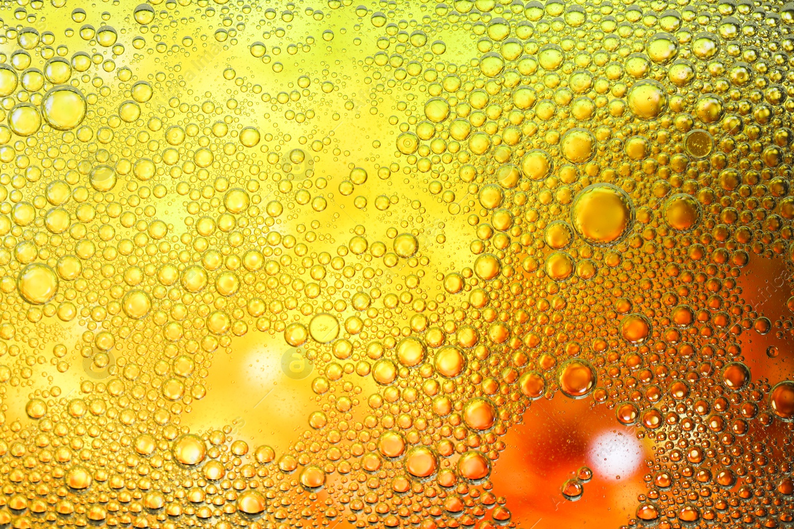 Photo of Essential oil bubbles on color background, macro view. Cosmetic product