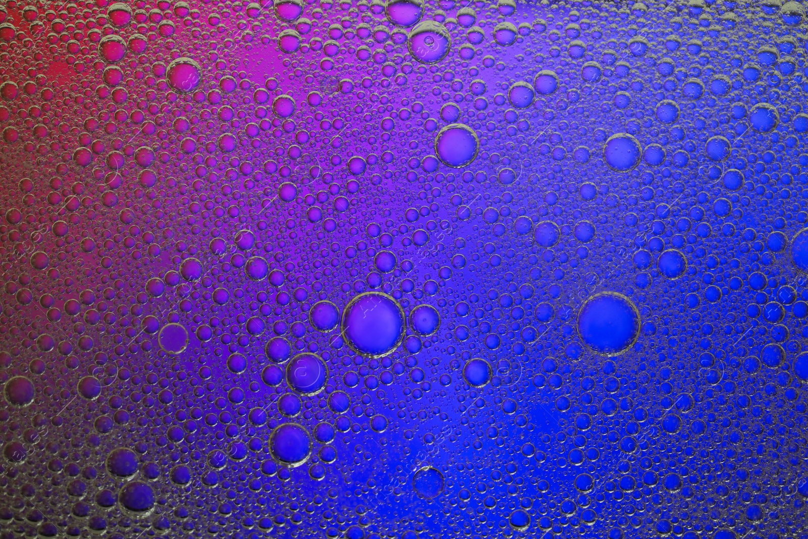 Photo of Essential oil bubbles on color background, macro view. Cosmetic product