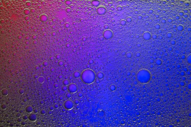 Essential oil bubbles on color background, macro view. Cosmetic product