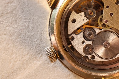 Photo of Mechanism of vintage wrist watch on beige table, top view. Space for text