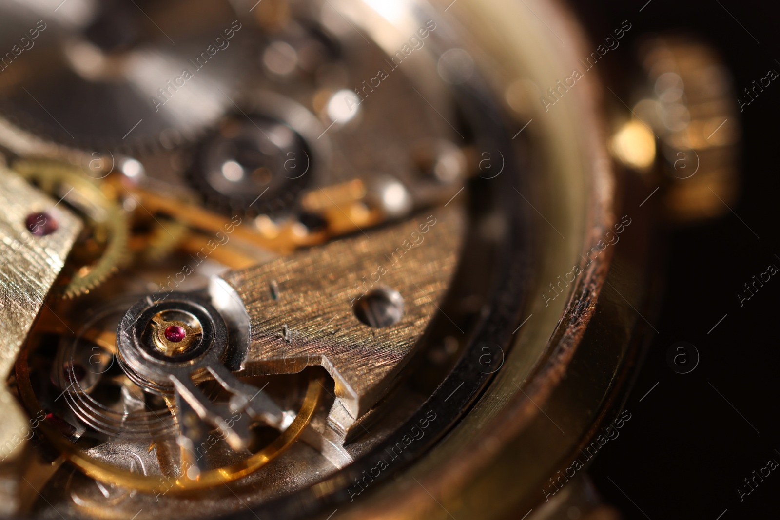 Photo of Mechanism of vintage wrist watch on black background, closeup