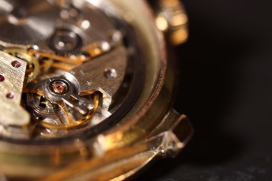 Mechanism of vintage wrist watch on black background, closeup