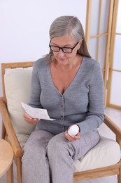 Photo of Senior woman with pills reading medicine instruction at home