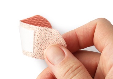 Photo of Woman putting medical adhesive bandage on white background, closeup