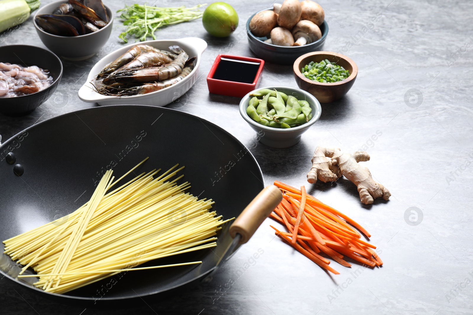 Photo of Different ingredients for wok on grey textured table