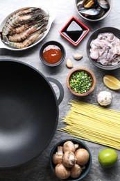 Photo of Different ingredients for wok on grey textured table, flat lay