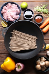 Photo of Different ingredients for wok on wooden table, flat lay