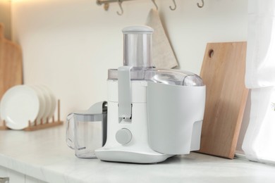 Photo of Modern juicer on white marble counter in kitchen