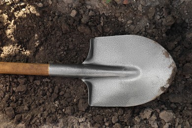 Photo of Metal shovel on soil outdoors, top view