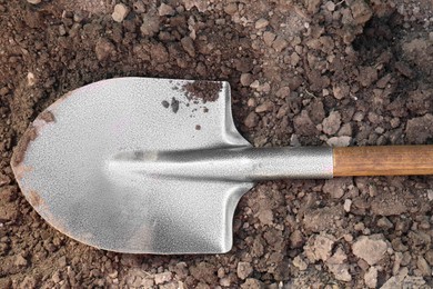 Photo of Metal shovel on soil outdoors, top view