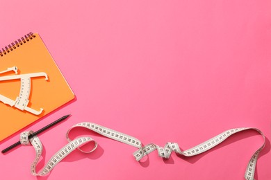 Photo of Body fat caliper, measuring tape, notebook and pencil on pink background, flat lay. Space for text