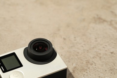 Modern action camera on stone surface, closeup. Space for text