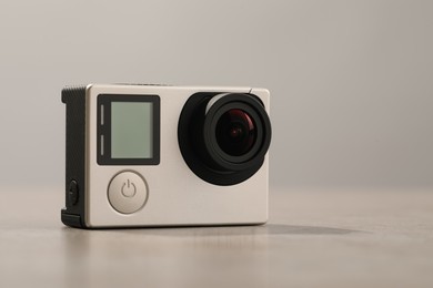 Modern action camera on light grey background, closeup. Space for text