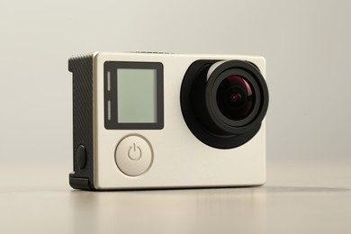 Modern action camera on light grey background, closeup