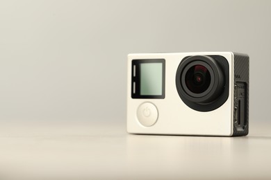 Modern action camera on light background, closeup. Space for text