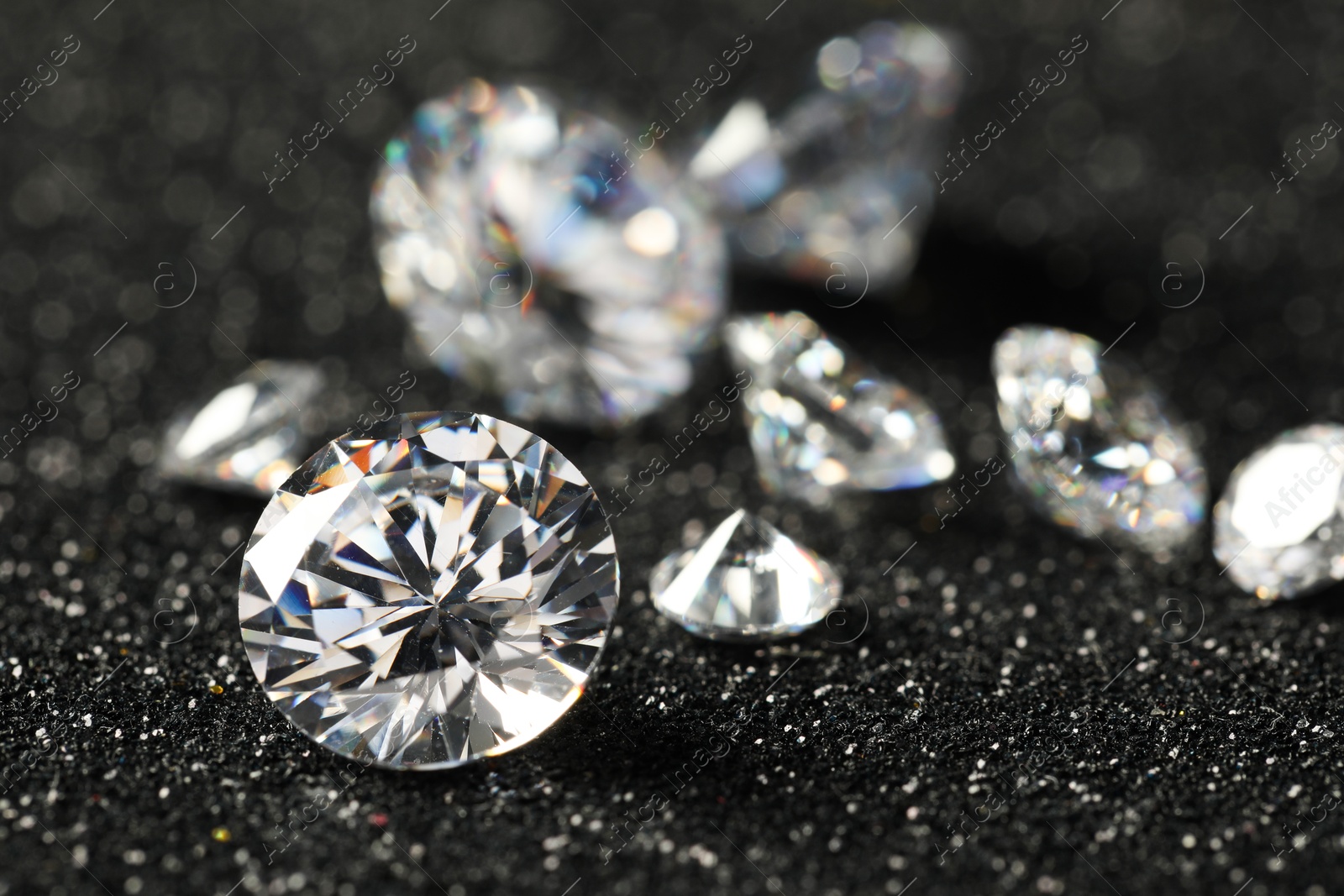 Photo of Beautiful dazzling diamonds on dark shiny background, closeup