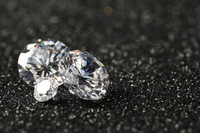 Photo of Beautiful dazzling diamonds on dark shiny background, closeup. Space for text