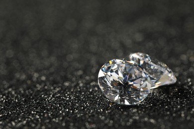 Photo of Beautiful dazzling diamonds on dark shiny background, closeup. Space for text