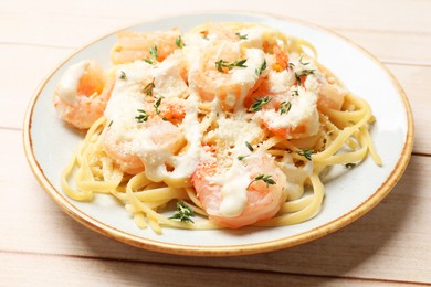 Photo of Tasty pasta with shrimps, creamy sauce and cheese on light wooden table, closeup