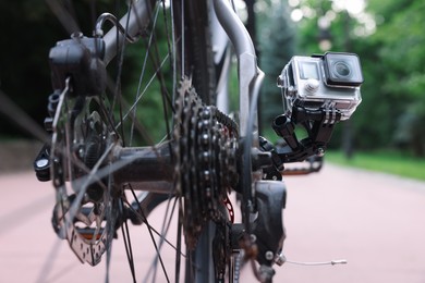 Modern action camera with mount on bicycle outdoors, closeup