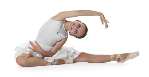 Cute little ballerina stretching on white background