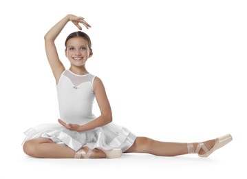 Photo of Cute little ballerina stretching on white background