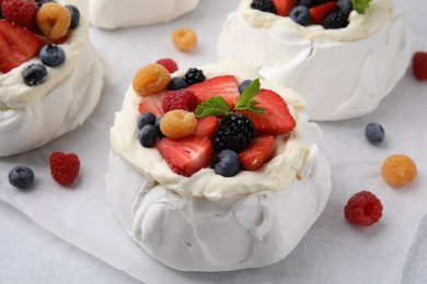 Photo of Pavlova cake (meringue dessert) with whipped cream and fresh berries on table, closeup