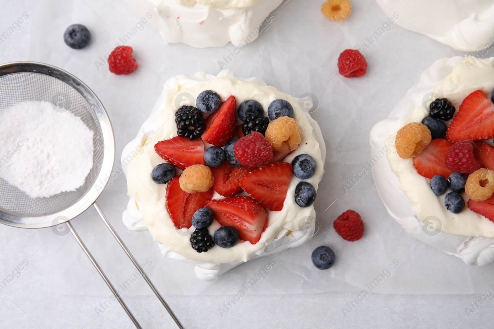 Photo of Pavlova cake (meringue dessert) with whipped cream and fresh berries on table, flat lay