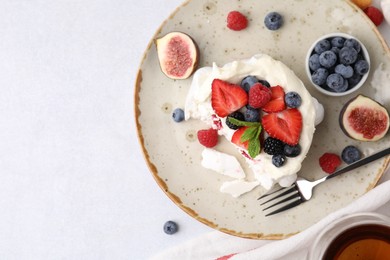 Photo of Pavlova cake (meringue dessert) with whipped cream, fresh berries, mint and fig on light table, top view. Space for text