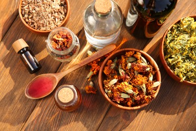 Photo of Different tinctures and ingredients on wooden table, flat lay