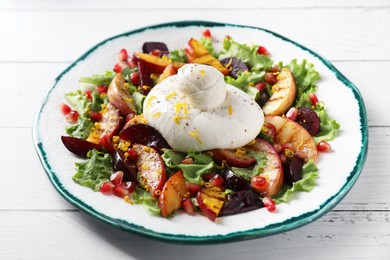 Photo of Plate with fresh burrata salad on white wooden table, closeup