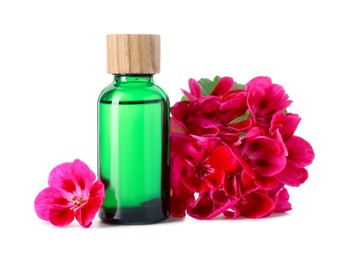 Photo of Geranium essential oil in bottle and beautiful flowers isolated on white