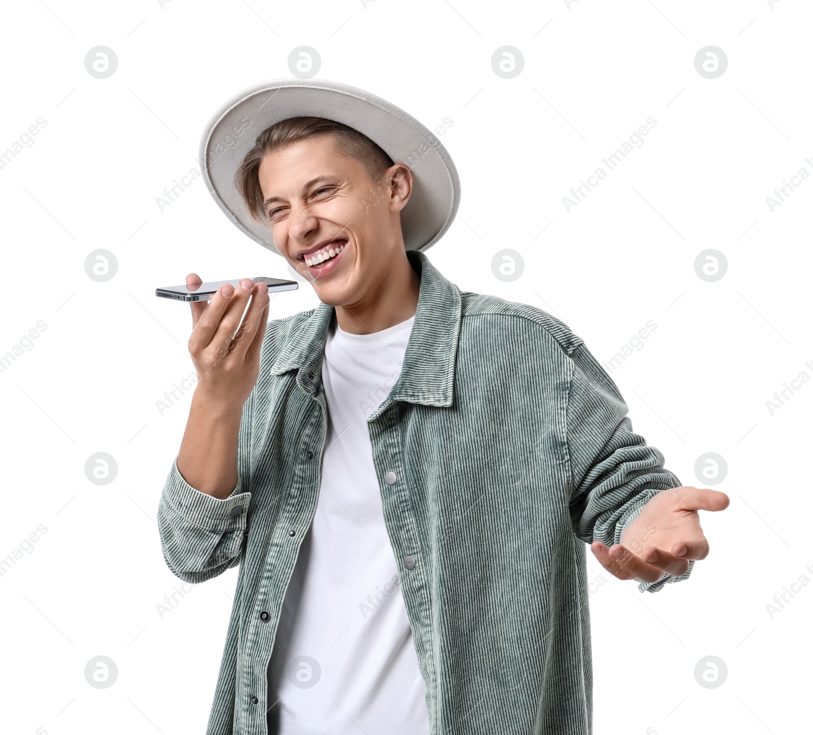 Photo of Young man in hat recording voice message via smartphone on white background