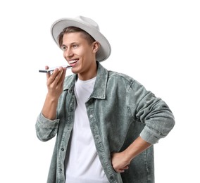 Photo of Young man in hat recording voice message via smartphone on white background