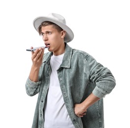 Photo of Young man in hat recording voice message via smartphone on white background