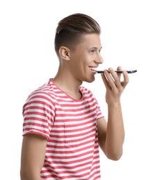 Young man recording voice message via smartphone on white background