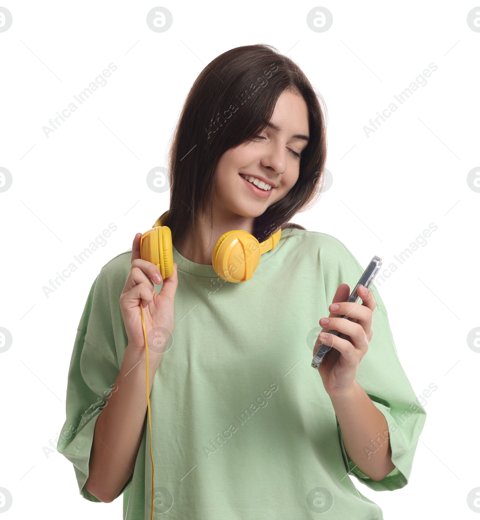 Photo of Portrait of cute teenage girl with headphones and smartphone on white background