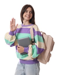 Teenage girl with backpack and book waving hello on white background