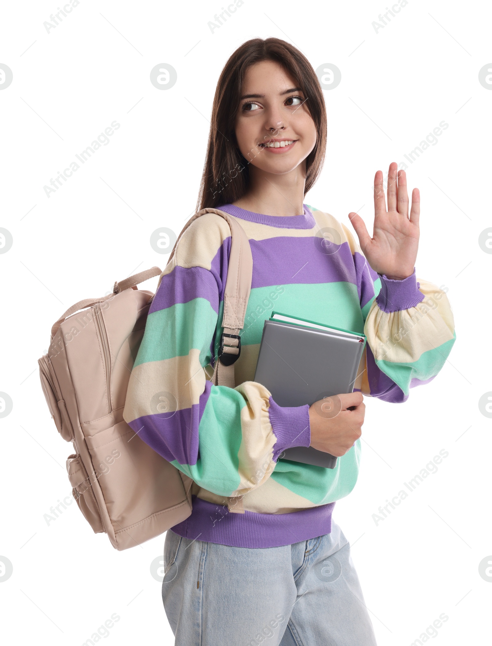 Photo of Teenage girl with backpack and book waving hello on white background