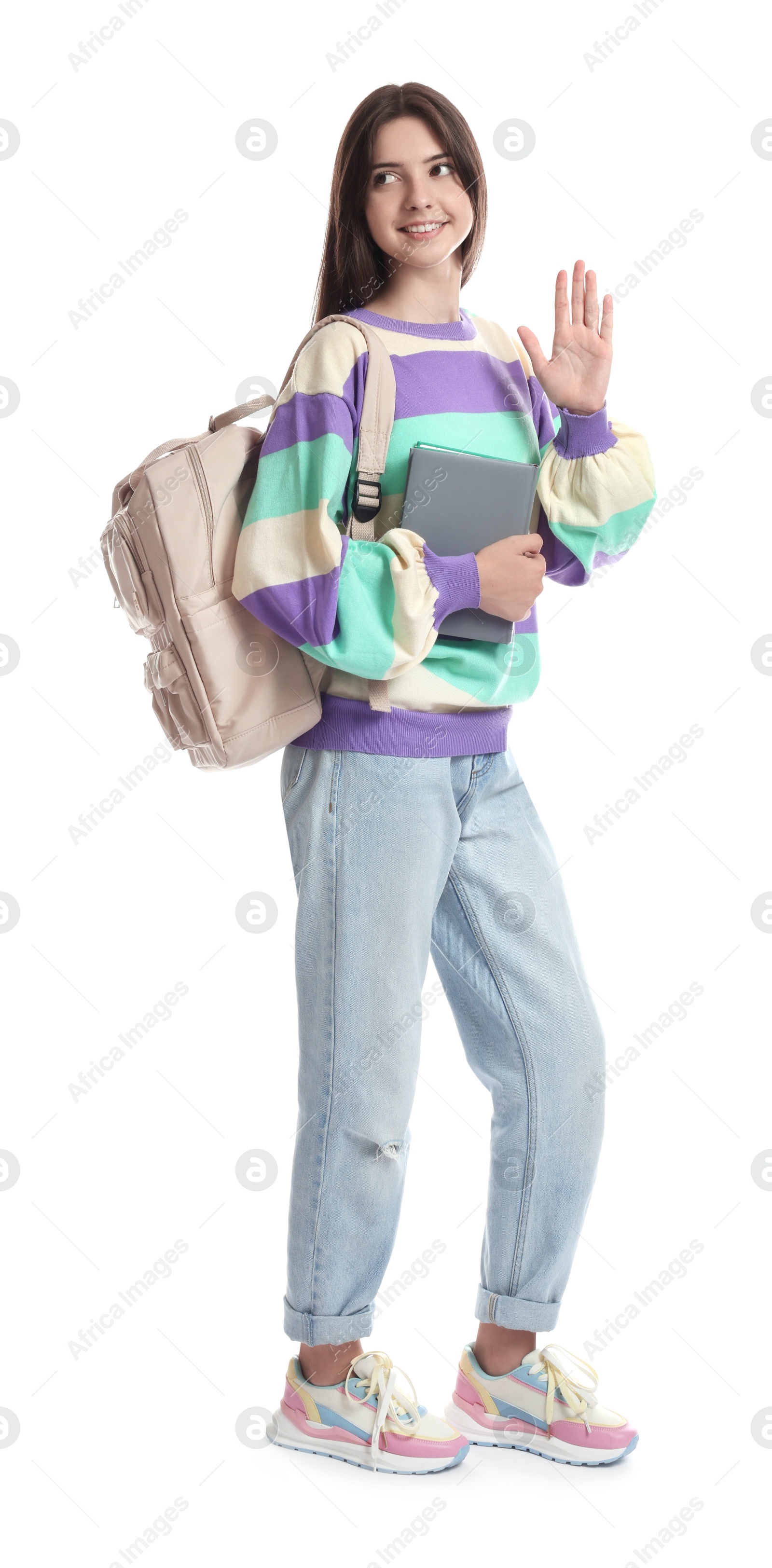 Photo of Teenage girl with backpack and book waving hello on white background