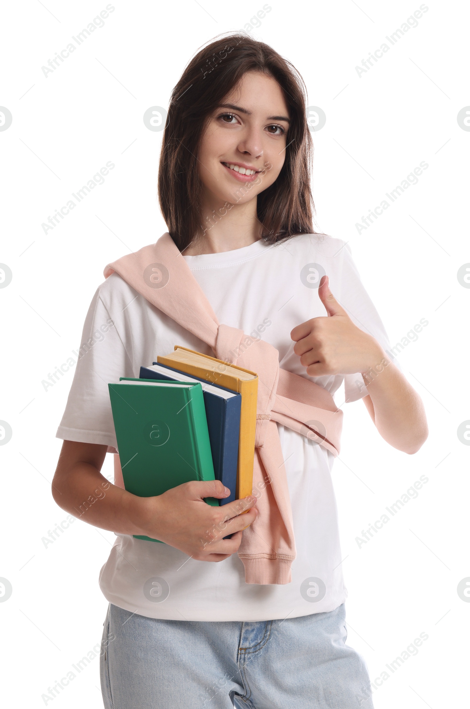 Photo of Portrait of cute teenage girl with books showing thumbs up on white background