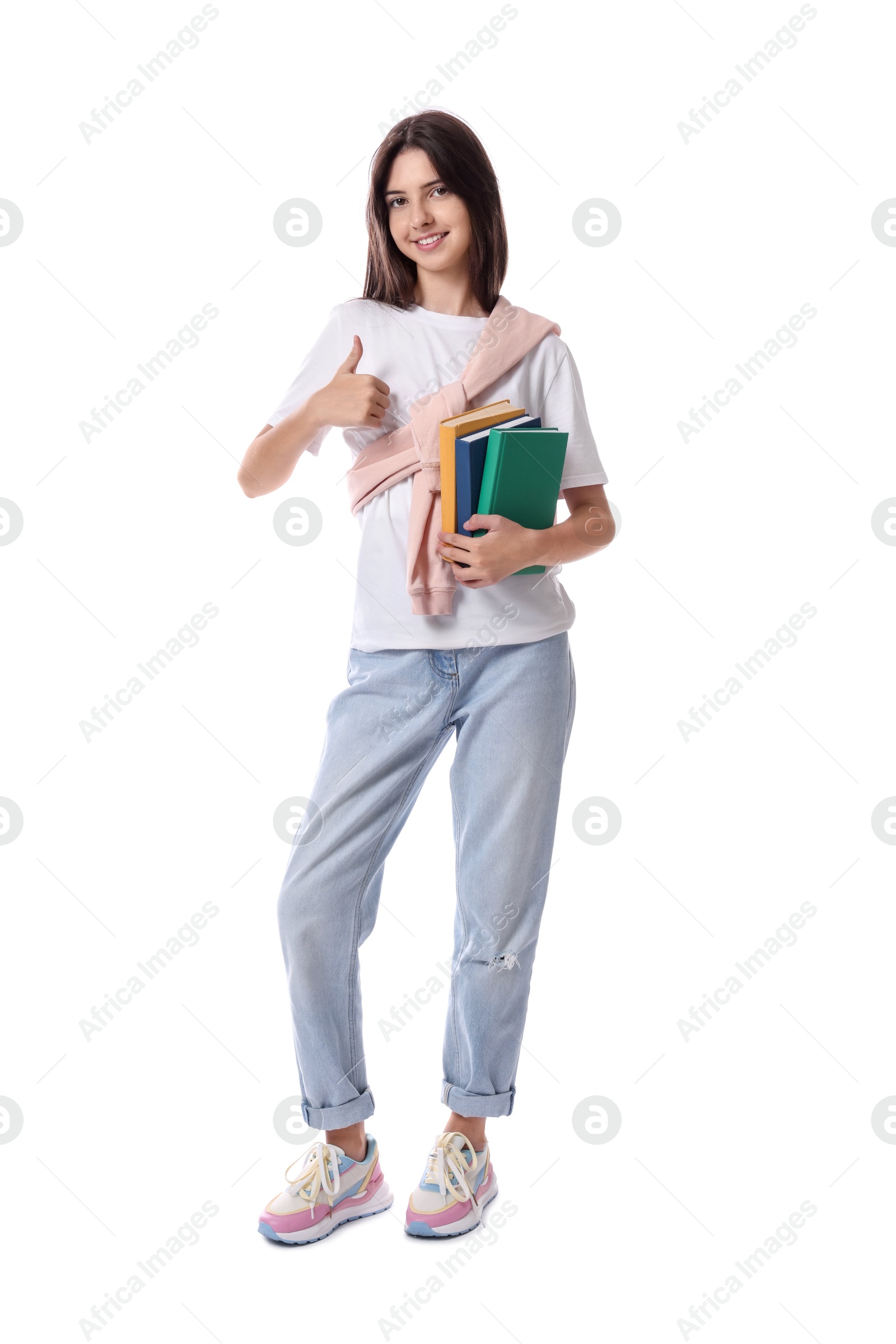 Photo of Cute teenage girl with books showing thumbs up on white background