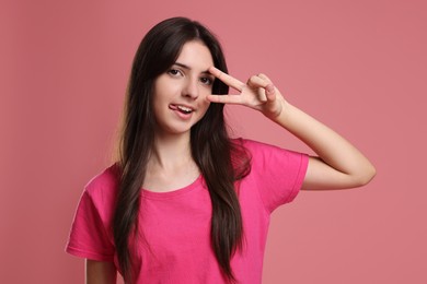 Photo of Portrait of cheerful teenage girl on pink background