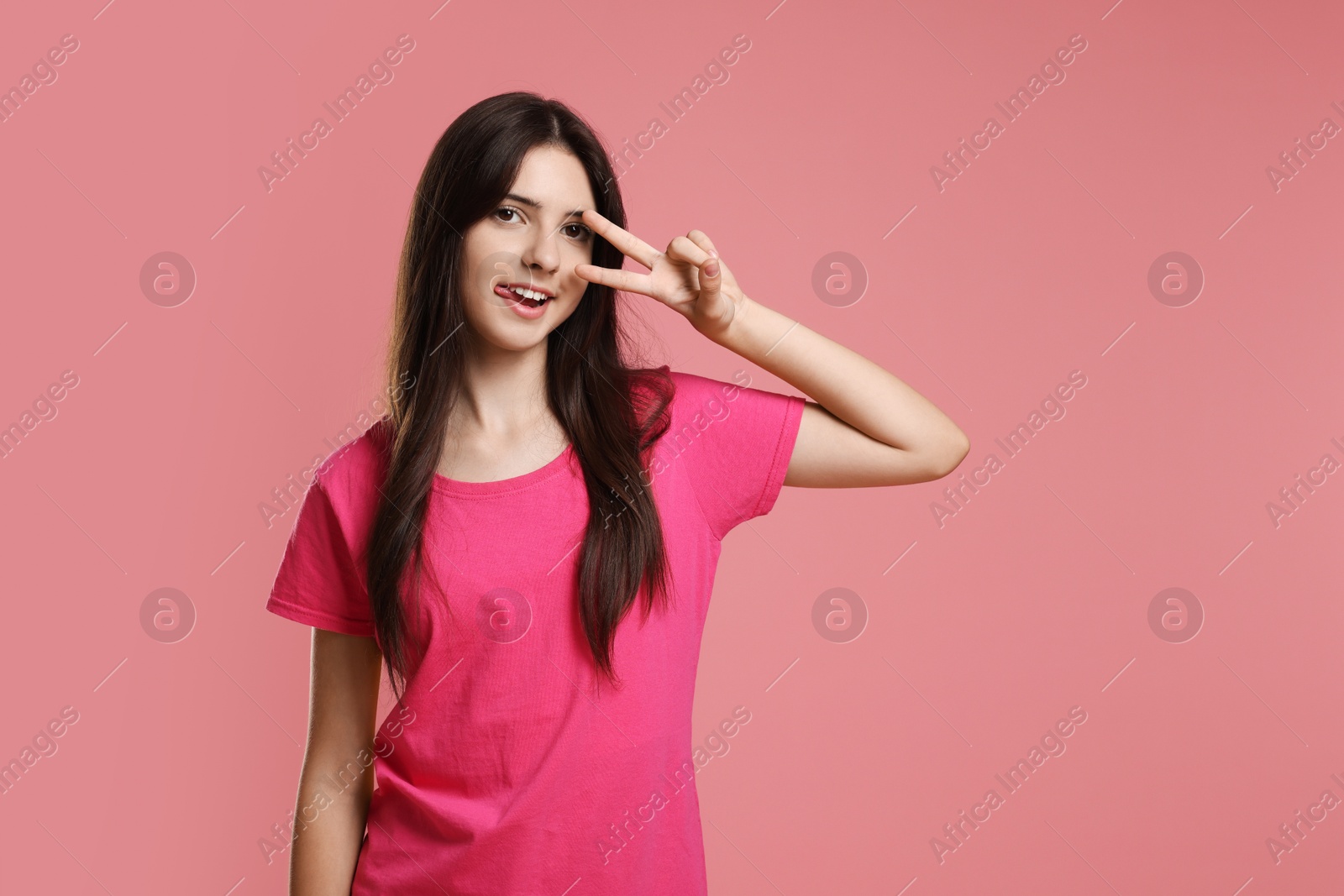 Photo of Portrait of cheerful teenage girl on pink background. Space for text