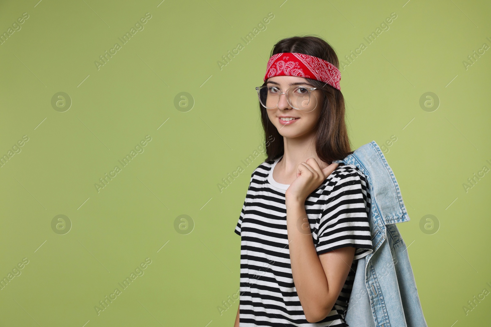 Photo of Portrait of cheerful teenage girl jumping on olive background. Space for text