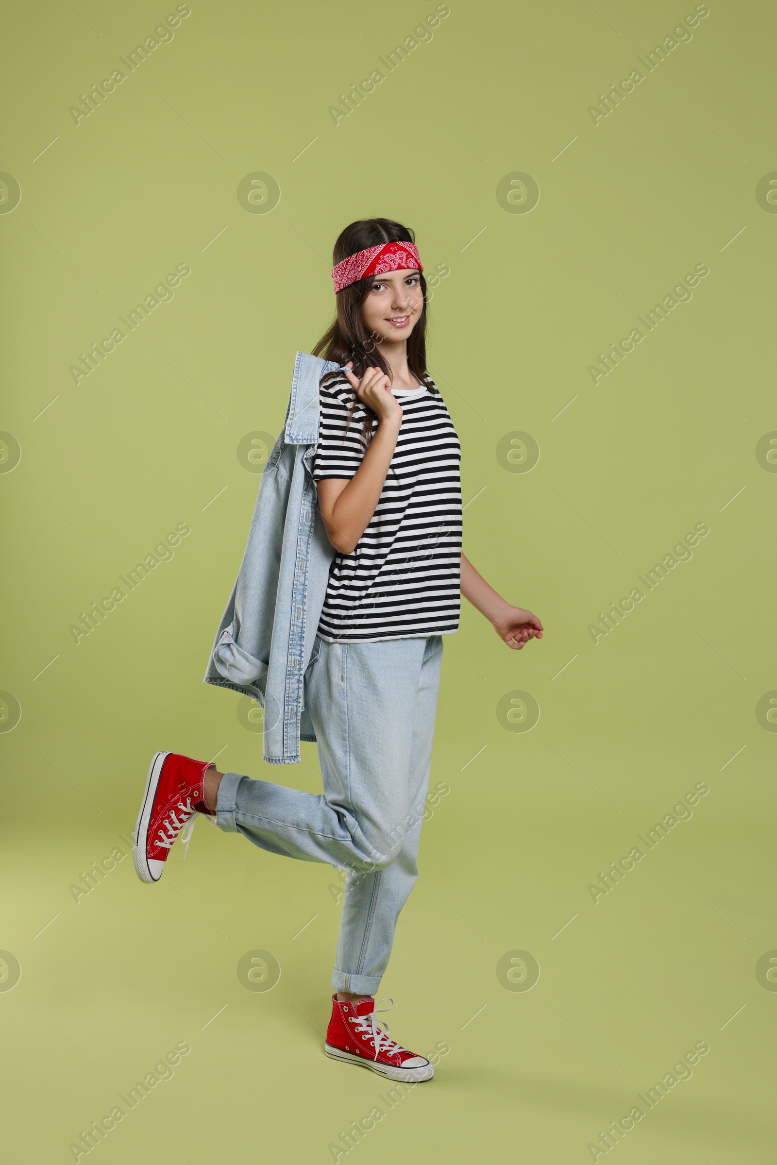 Photo of Full length portrait of cheerful teenage girl on olive background