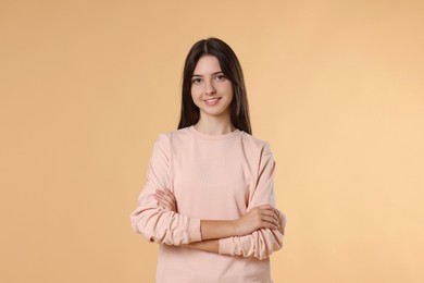 Portrait of cute teenage girl on beige background